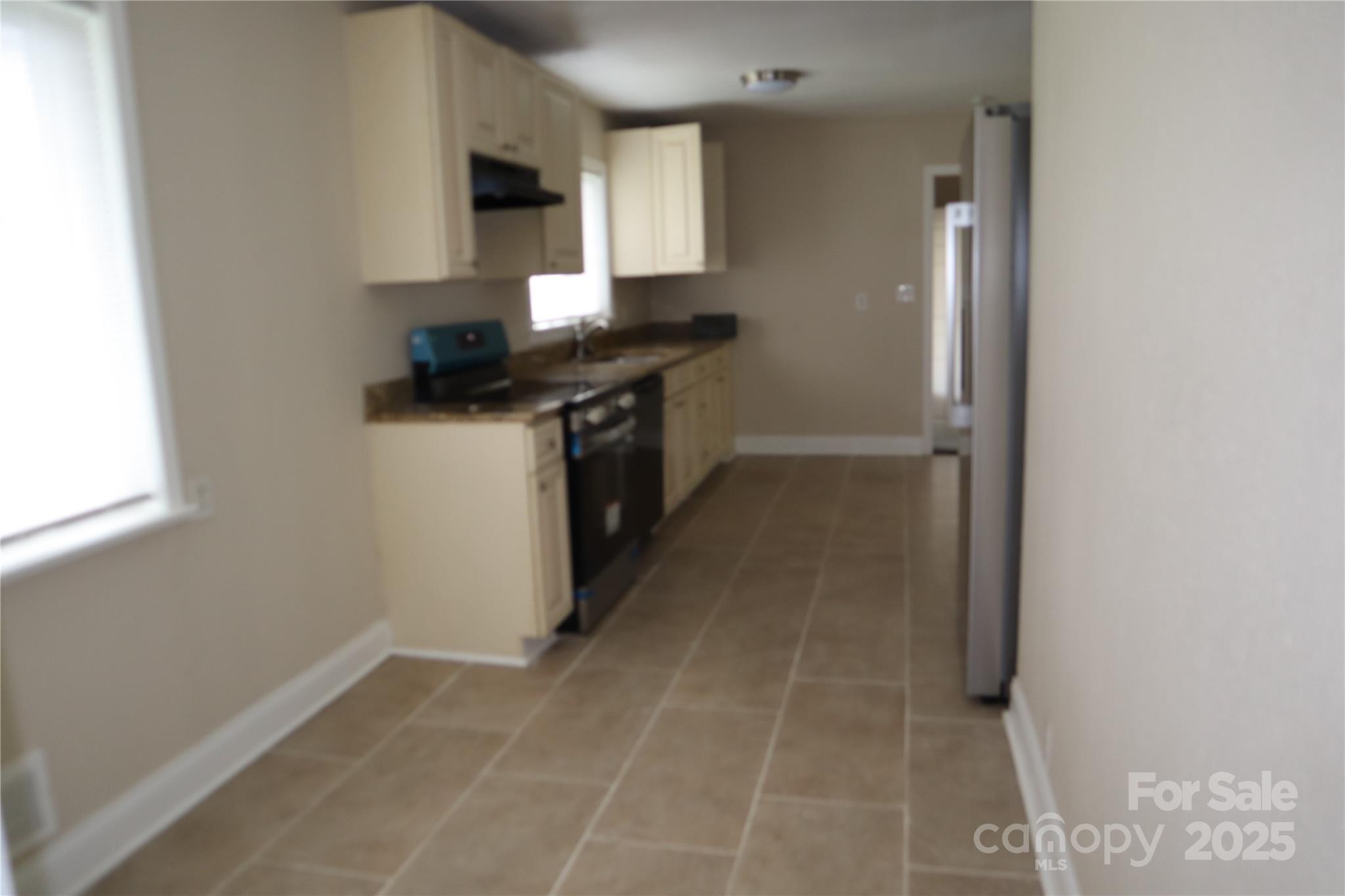 1703 Tyvola Road Charlotte, NC 28210 - Photo 5 of 17 a kitchen with granite countertop a sink and a stove top oven