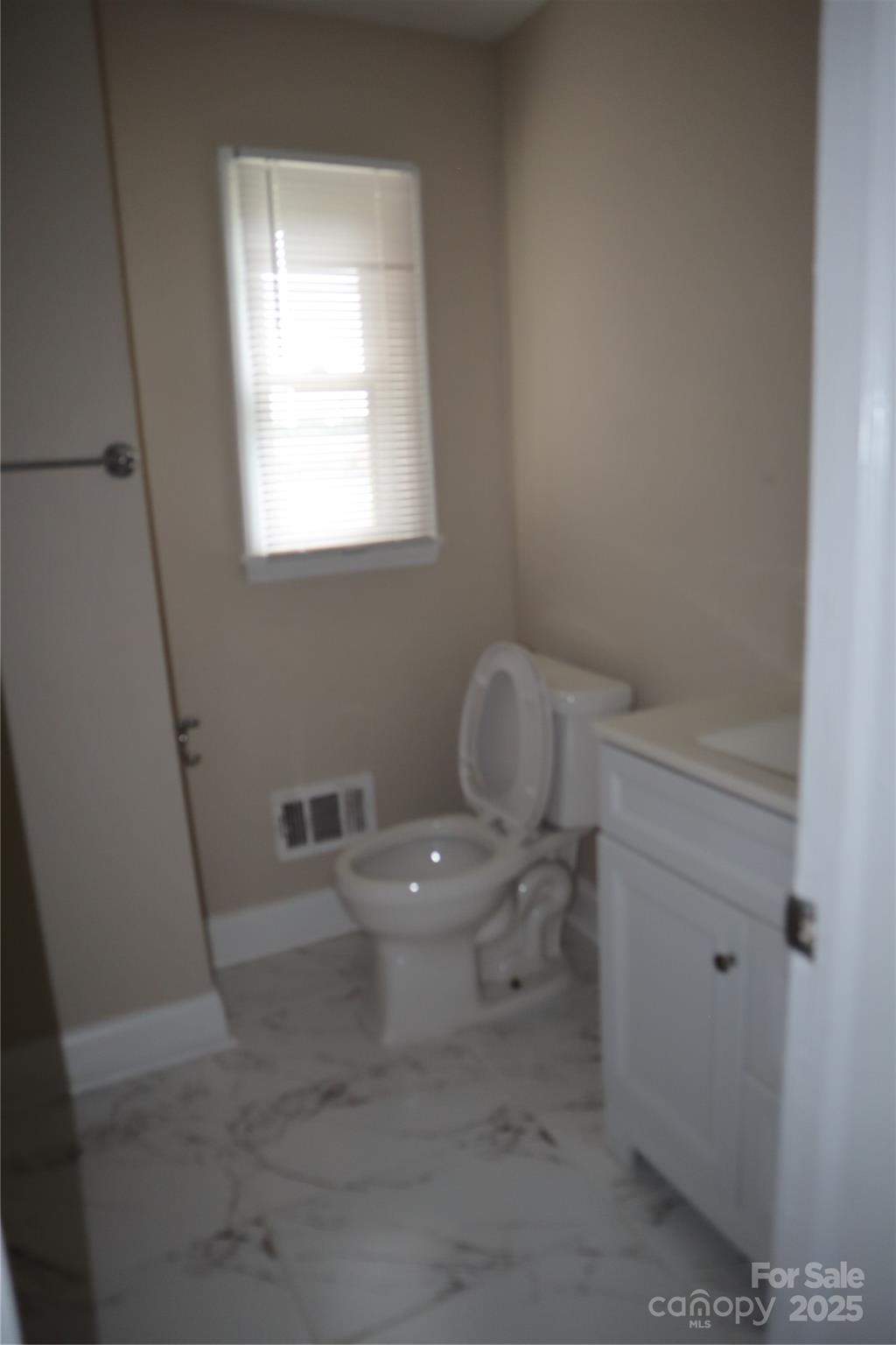 1703 Tyvola Road Charlotte, NC 28210 - Photo 7 of 17 a white toilet sitting next to a bathroom sink