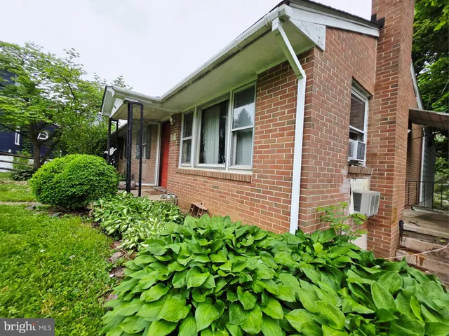 a view of a house with potted plants and a table and chair