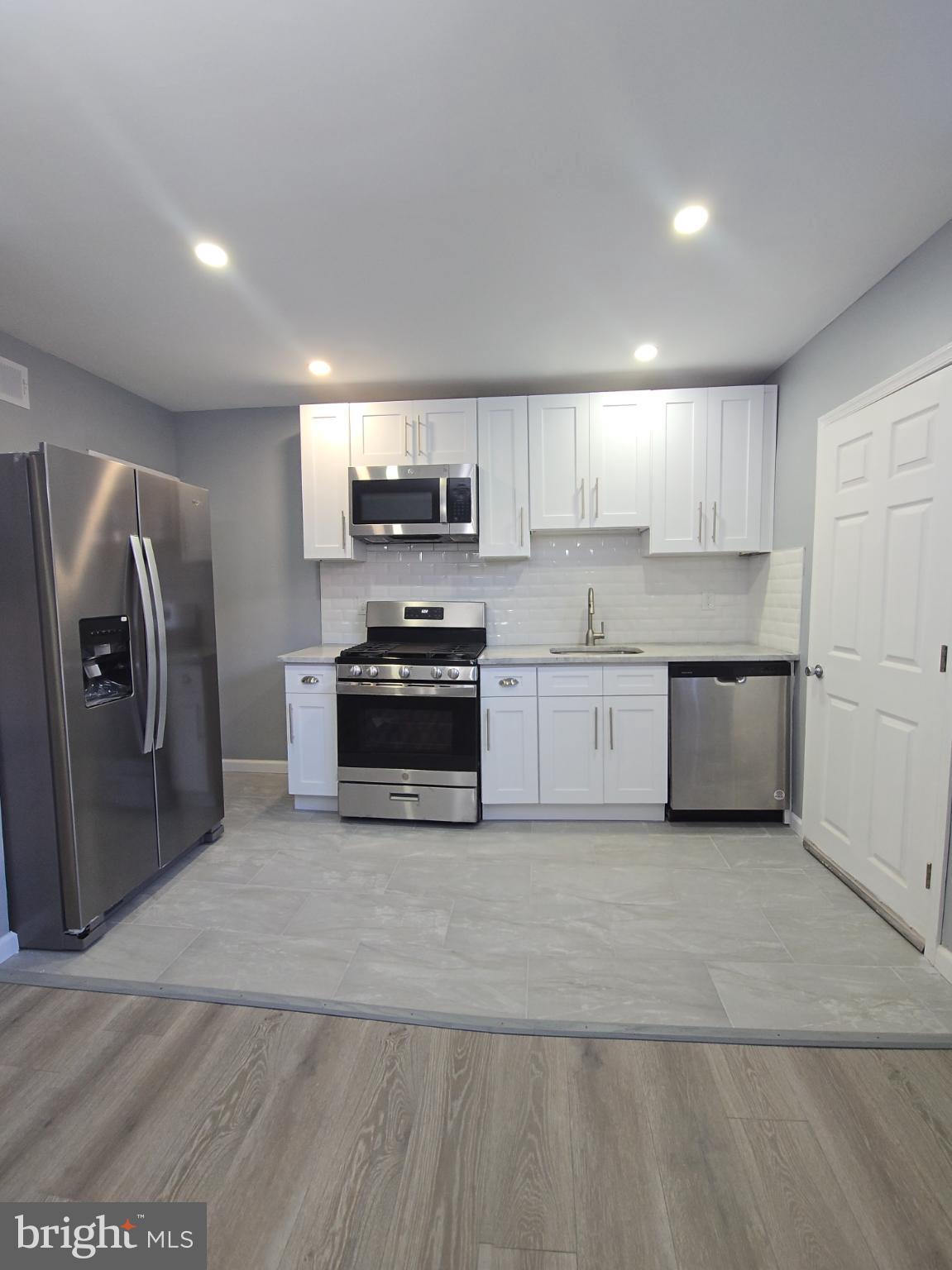 6733 Linmore Avenue Philadelphia, PA 19142 - Photo 11 of 55 a kitchen with stainless steel appliances a refrigerator sink and microwave
