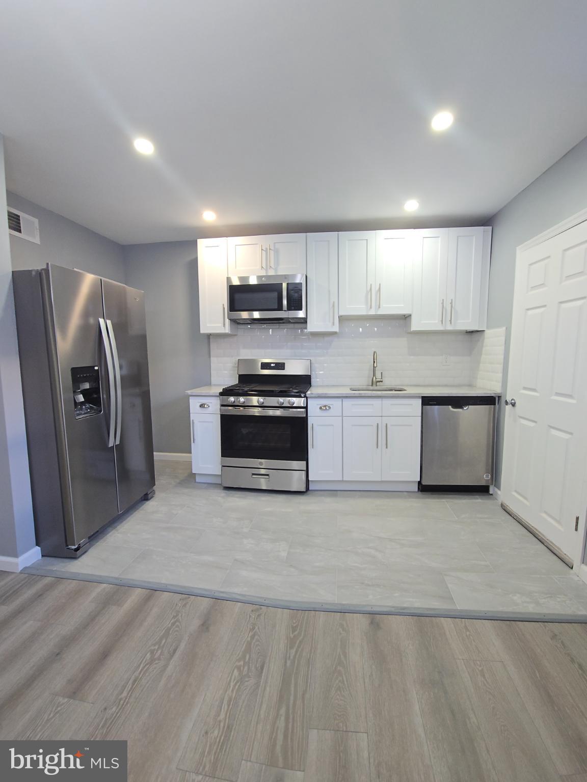 6733 Linmore Avenue Philadelphia, PA 19142 - Photo 12 of 55 a large kitchen with a refrigerator a stove top oven a sink and dishwasher