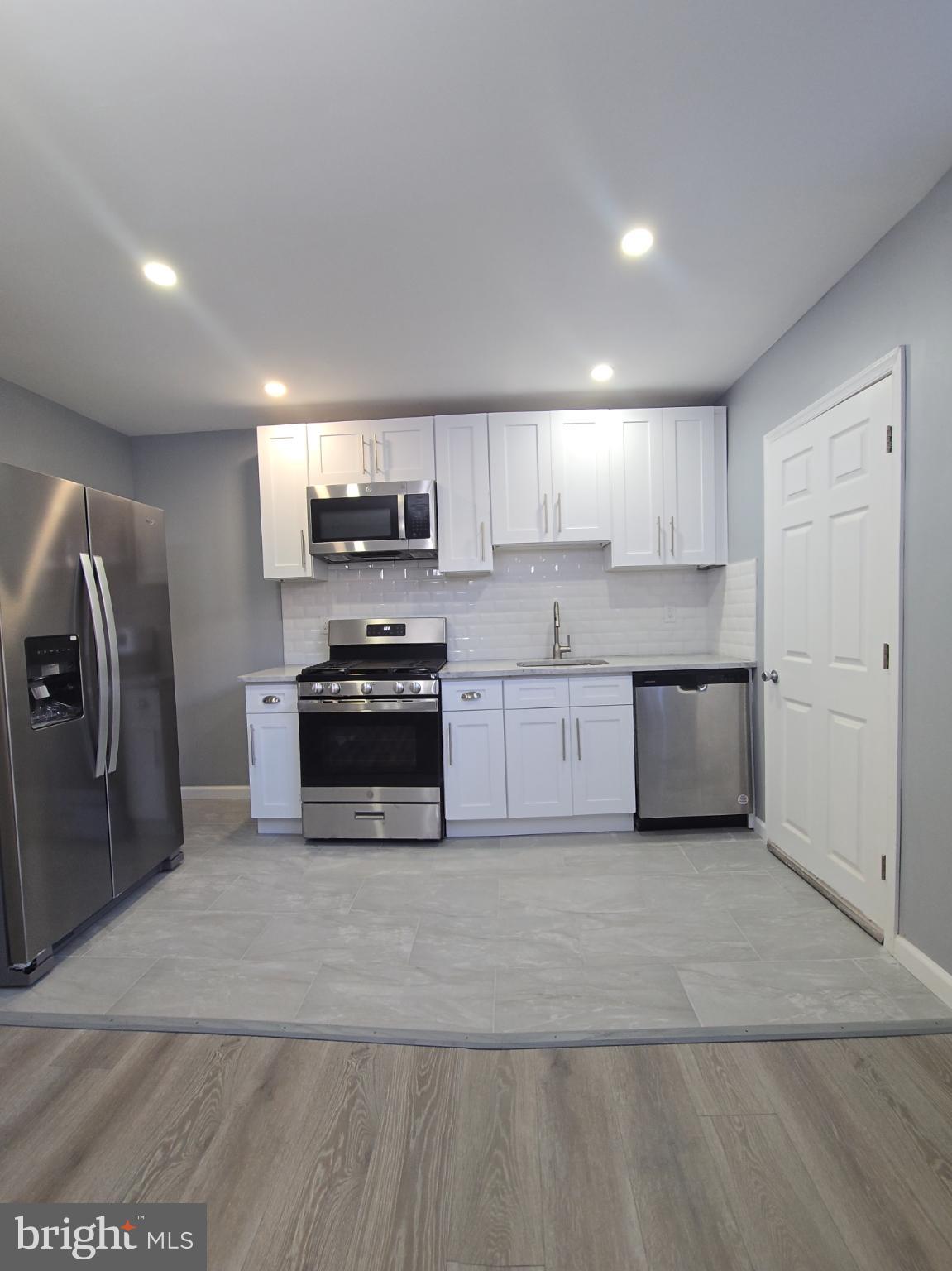 6733 Linmore Avenue Philadelphia, PA 19142 - Photo 13 of 55 a kitchen with stainless steel appliances granite countertop a stove a sink and a refrigerator