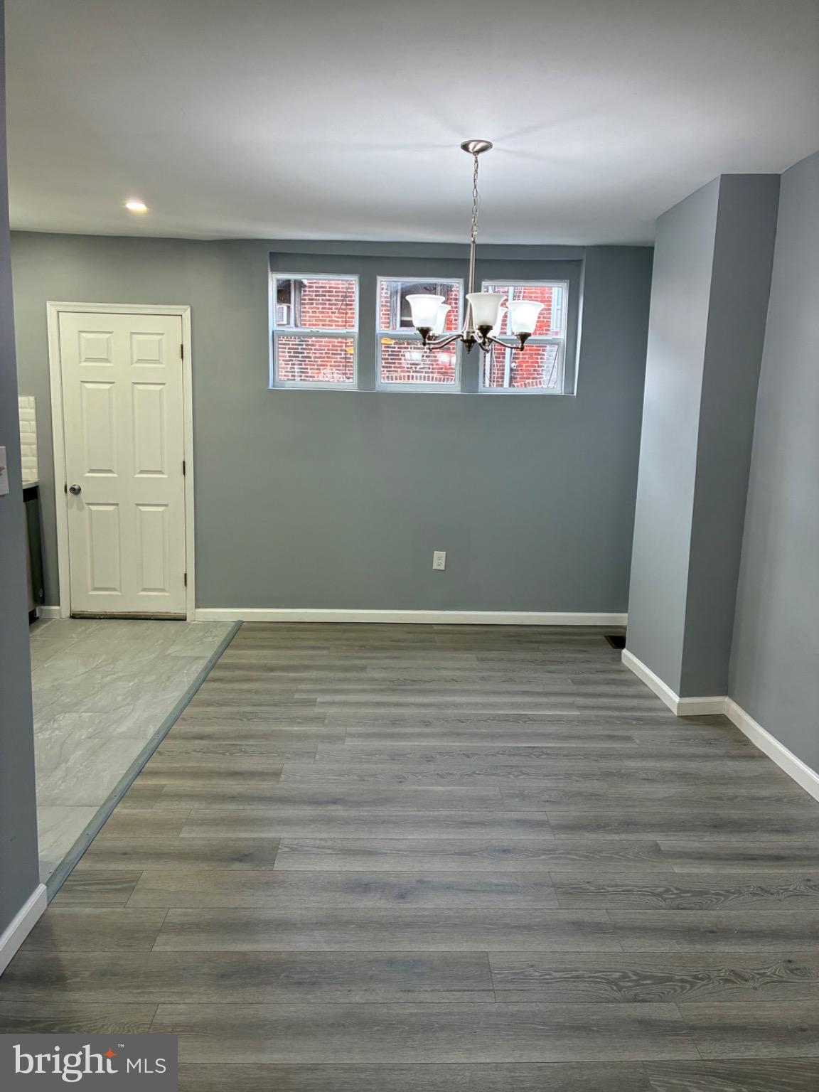 6733 Linmore Avenue Philadelphia, PA 19142 - Photo 34 of 55 an empty room with wooden floor kitchen view and windows