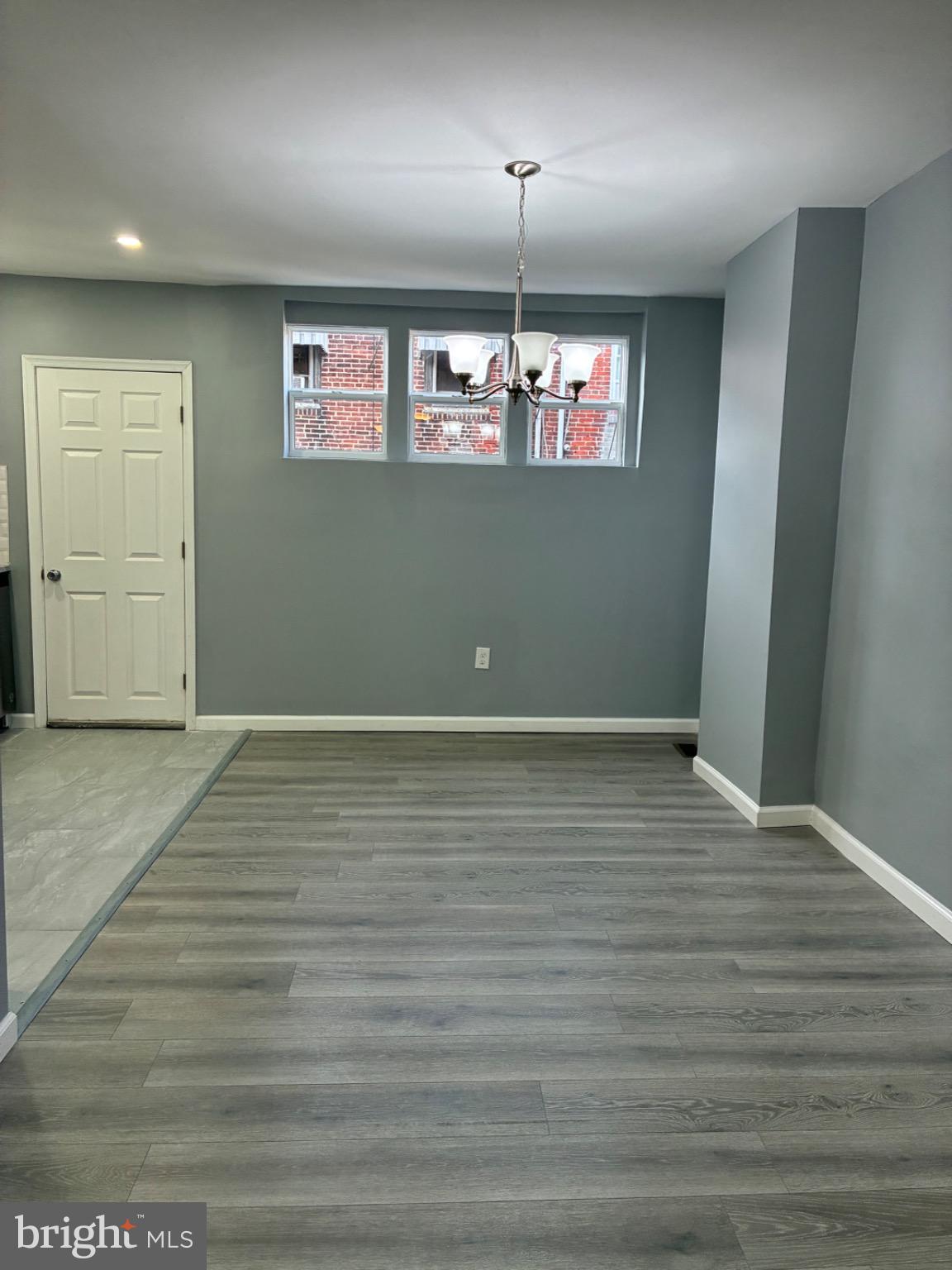 6733 Linmore Avenue Philadelphia, PA 19142 - Photo 35 of 55 an empty room with wooden floor chandelier and windows
