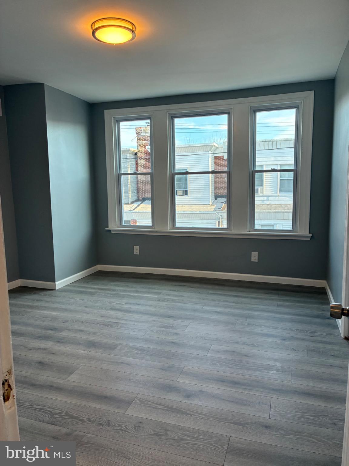 6733 Linmore Avenue Philadelphia, PA 19142 - Photo 42 of 55 an empty room with wooden floor and windows