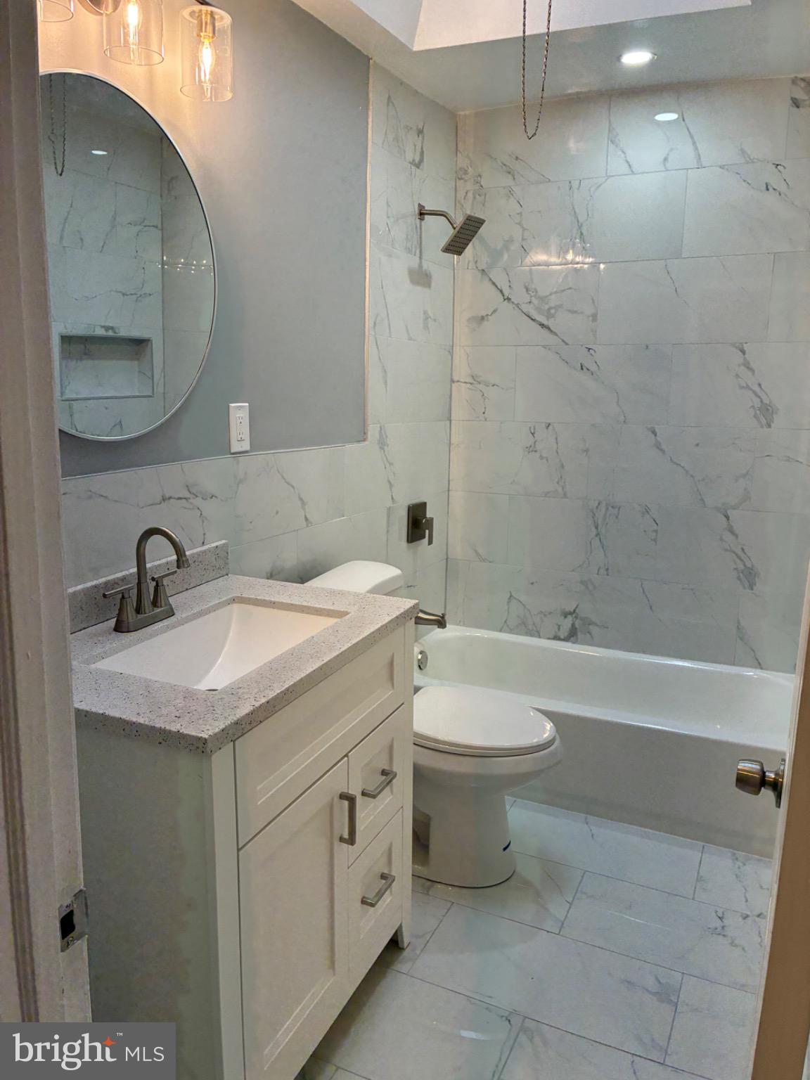 6733 Linmore Avenue Philadelphia, PA 19142 - Photo 47 of 55 a bathroom with a granite countertop sink a toilet and bathtub