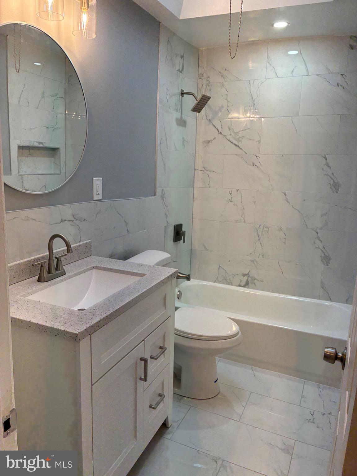 6733 Linmore Avenue Philadelphia, PA 19142 - Photo 48 of 55 a bathroom with a granite countertop sink a toilet and bathtub