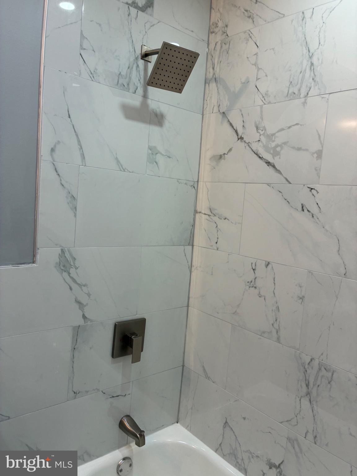 6733 Linmore Avenue Philadelphia, PA 19142 - Photo 51 of 55 a bathroom with a shower and a tiled wall