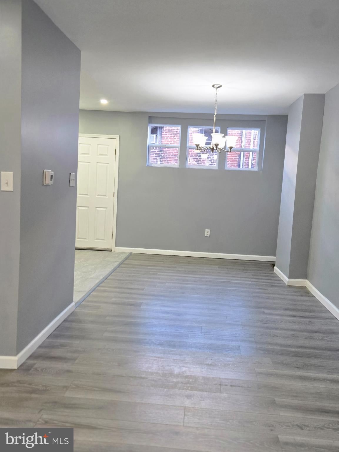 6733 Linmore Avenue Philadelphia, PA 19142 - Photo 8 of 55 an empty room with wooden floor and windows
