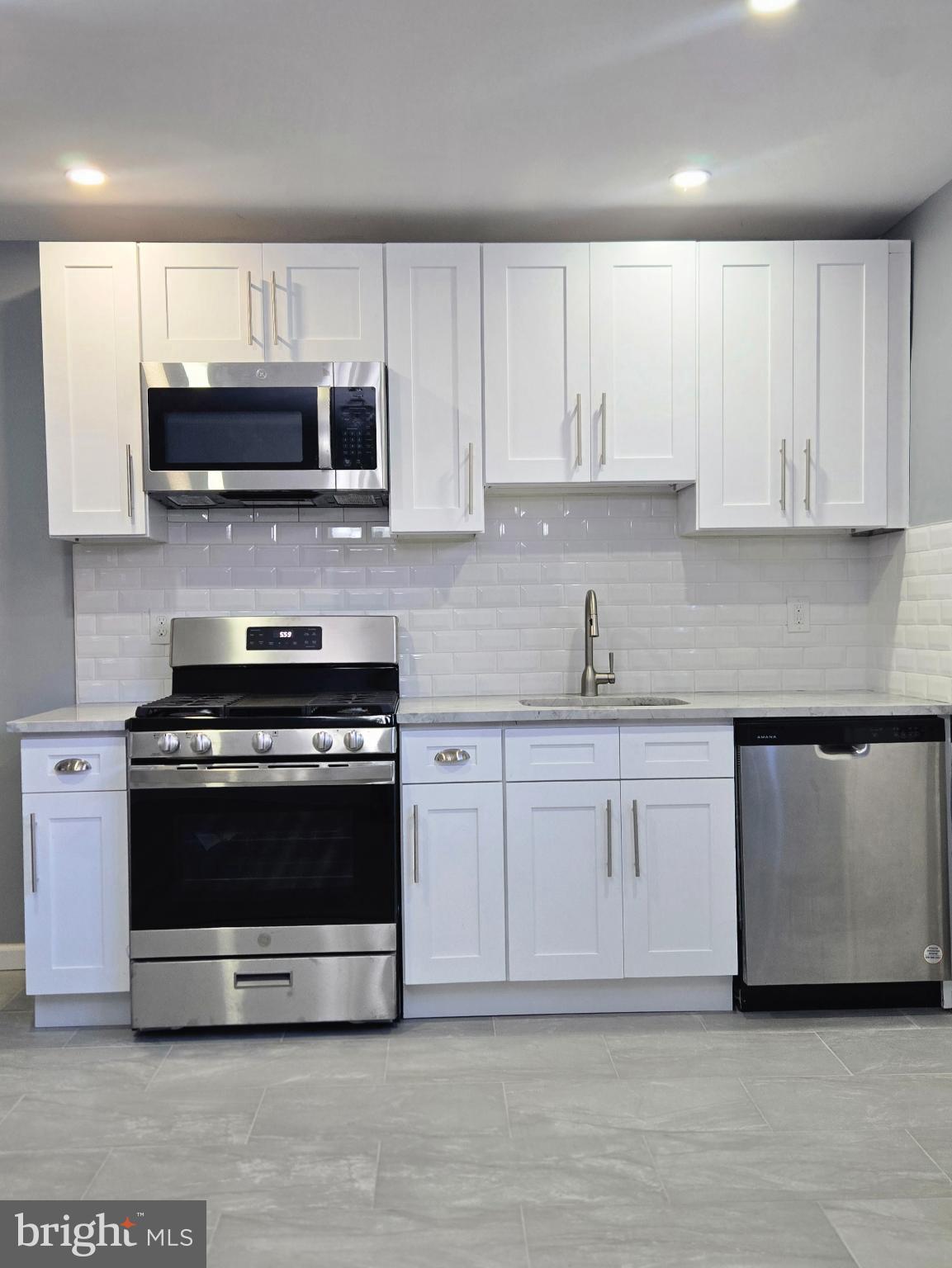 6733 Linmore Avenue Philadelphia, PA 19142 - Photo 10 of 55 a kitchen with stainless steel appliances granite countertop a stove a sink and a microwave