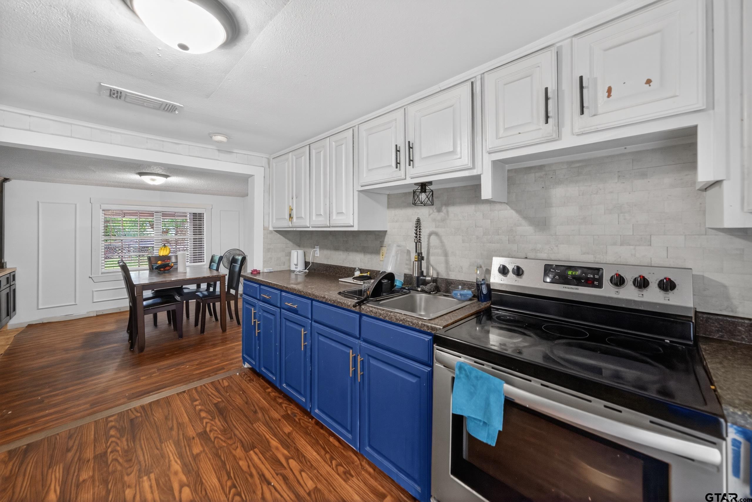 319 McArthur Street Athens, TX 75751 - Photo 11 of 33 a kitchen with wooden cabinets and a stove top oven
