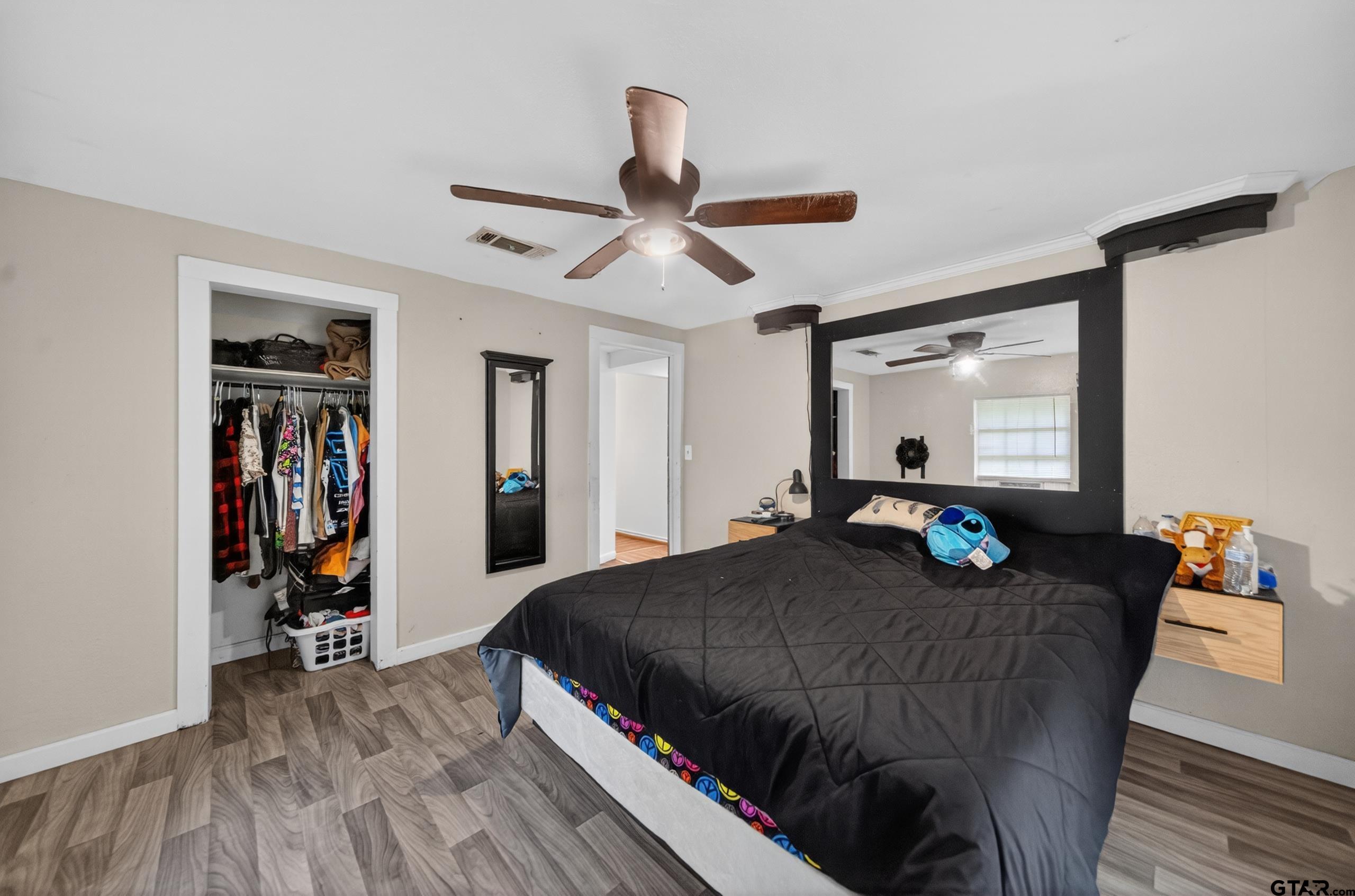 319 McArthur Street Athens, TX 75751 - Photo 18 of 33 a bedroom with a bed and a chandelier