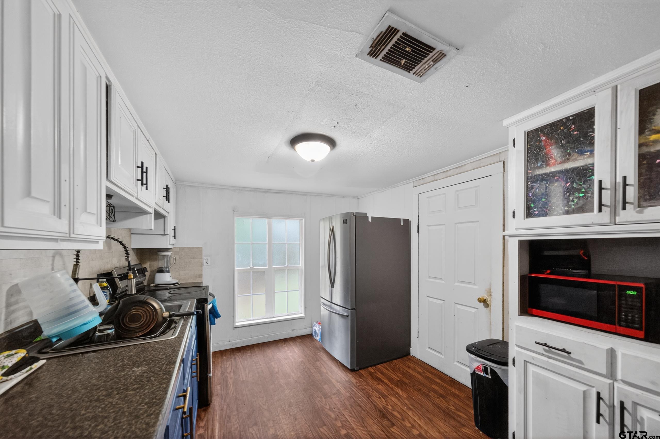319 McArthur Street Athens, TX 75751 - Photo 8 of 33 a view of a kitchen with fridge and wooden floor
