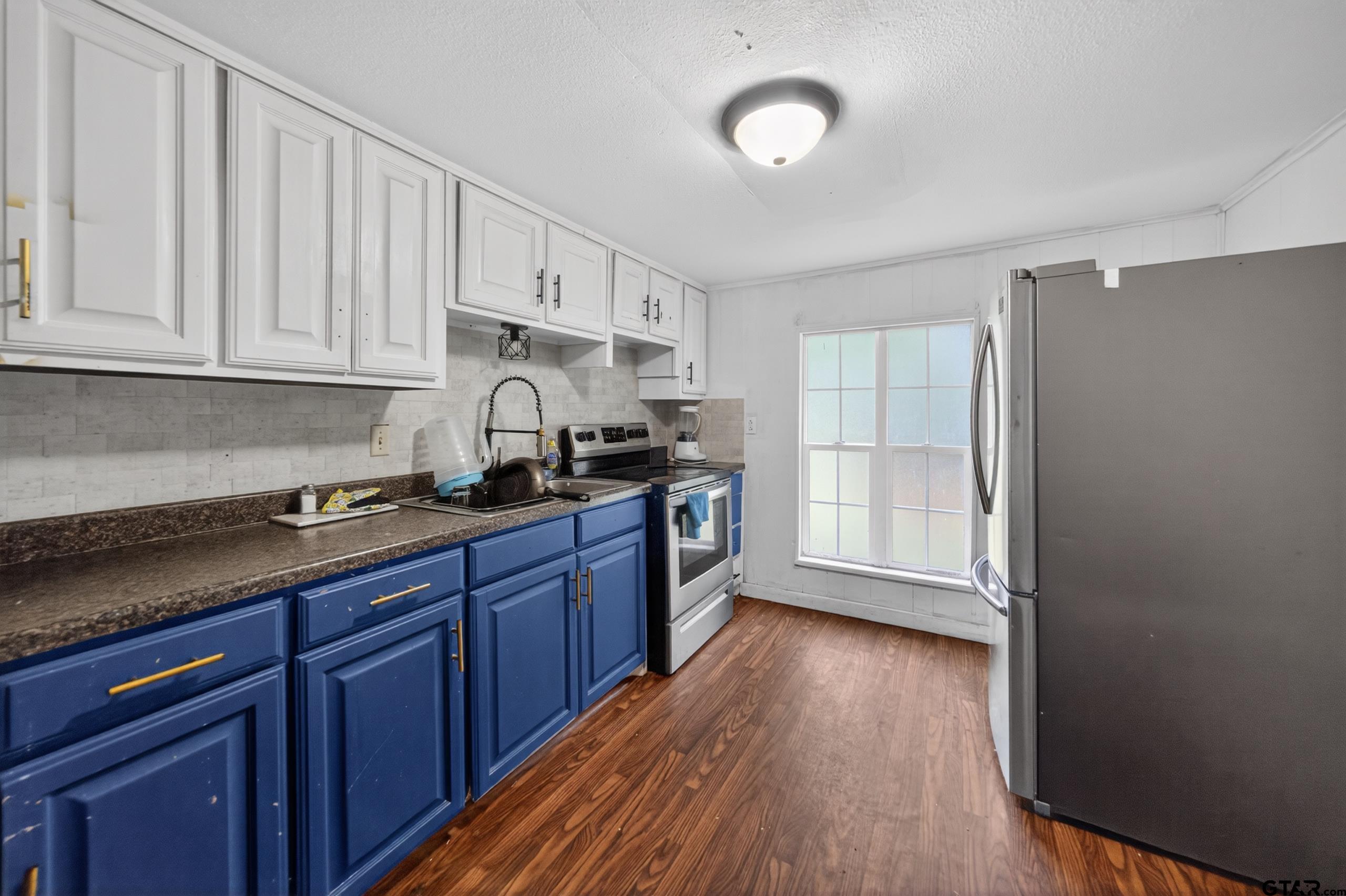 319 McArthur Street Athens, TX 75751 - Photo 9 of 33 a kitchen with granite countertop wooden cabinets and a stove