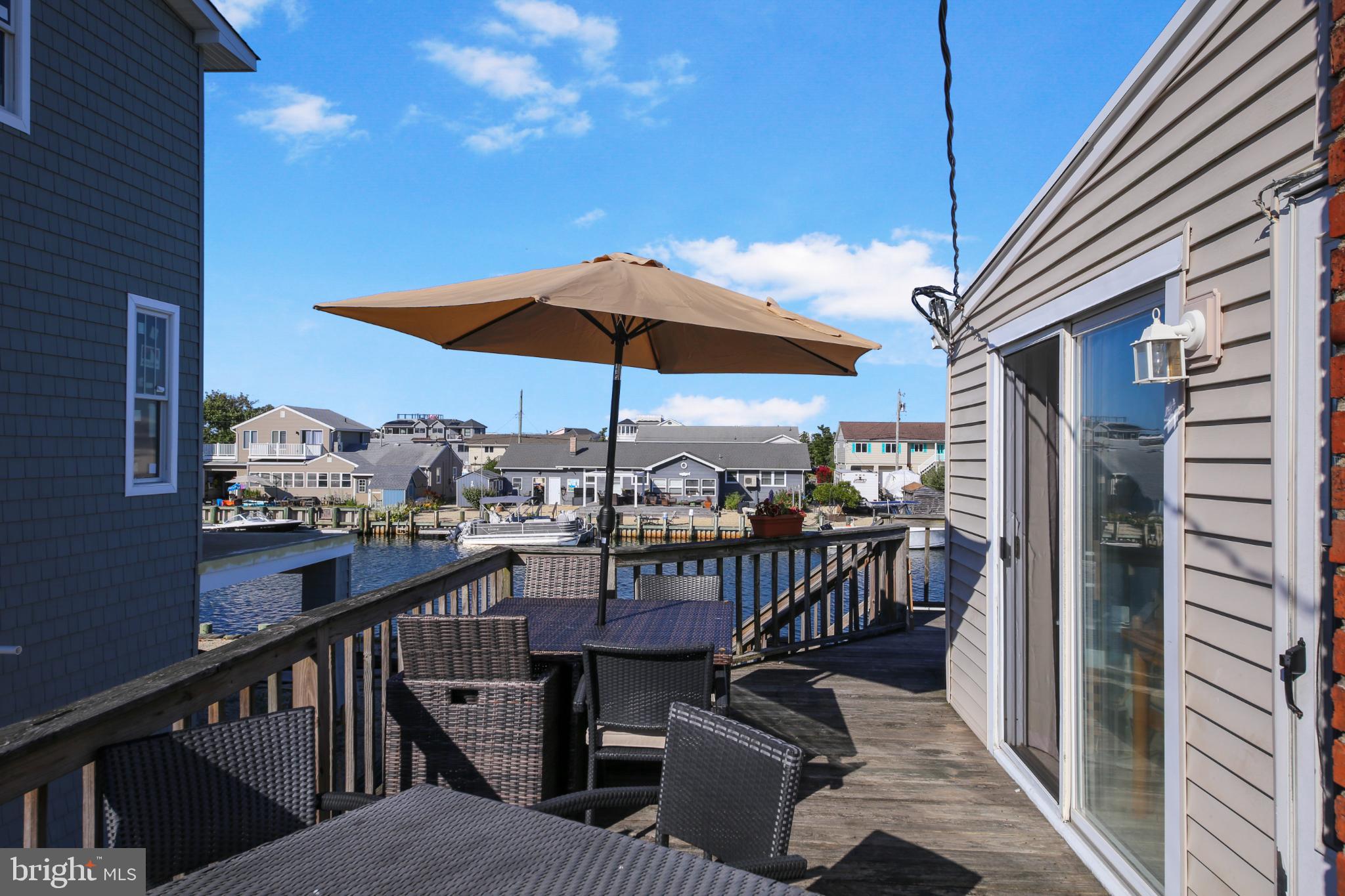 33 Adrian Road Long Beach Township, NJ 08006 - Photo 21 of 31 a view of a balcony with chairs and umbrella