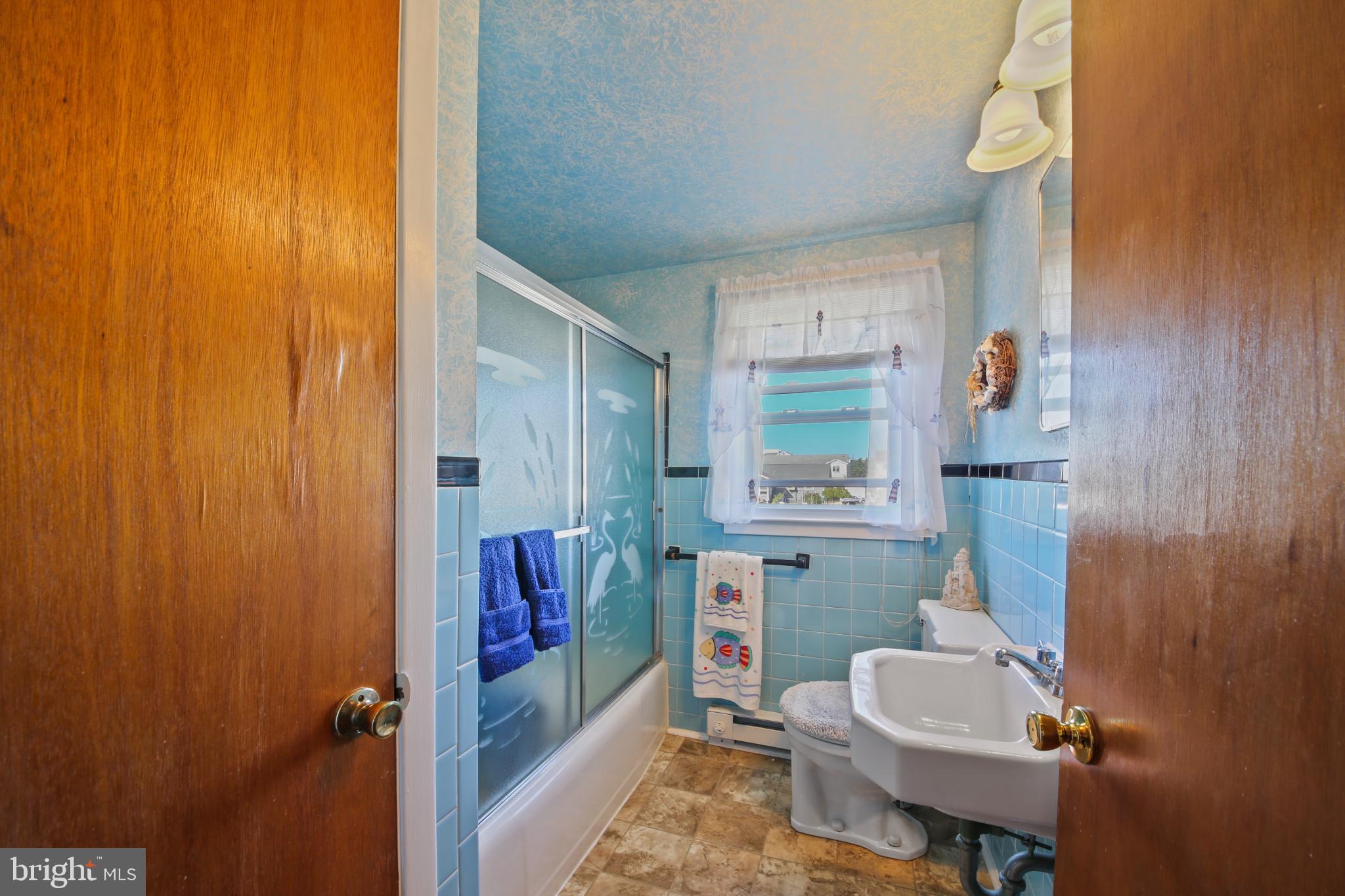 33 Adrian Road Long Beach Township, NJ 08006 - Photo 23 of 31 a bathroom with a sink a toilet and shower curtain