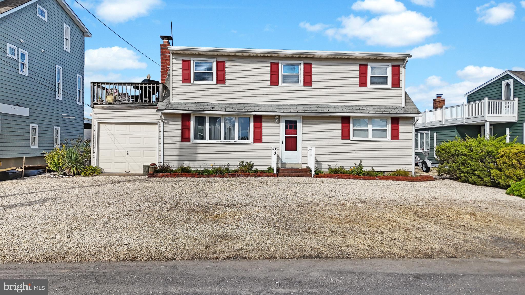 33 Adrian Road Long Beach Township, NJ 08006 - Photo 3 of 31 a front view of a house with a yard and garage