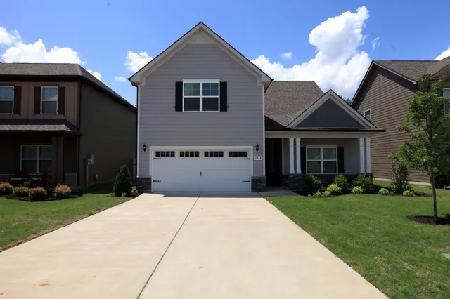 a front view of a house with a yard and garage