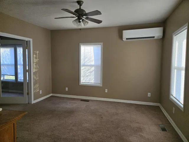 a view of room with a ceiling fan and windows