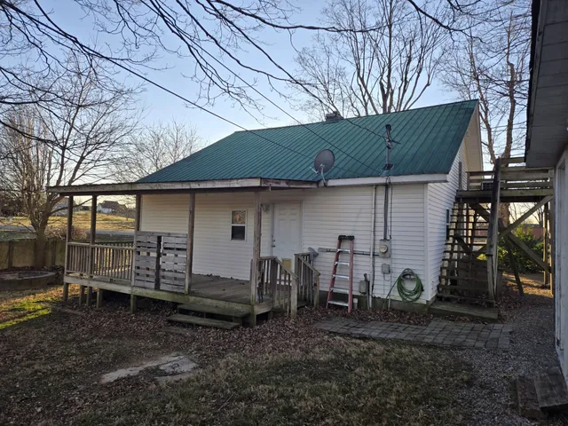 a view of a house with a backyard and chairs