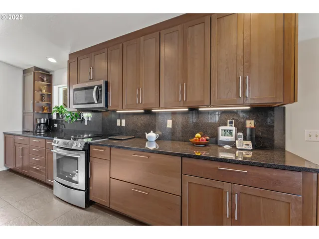 a kitchen with stainless steel appliances granite countertop a refrigerator sink and stove