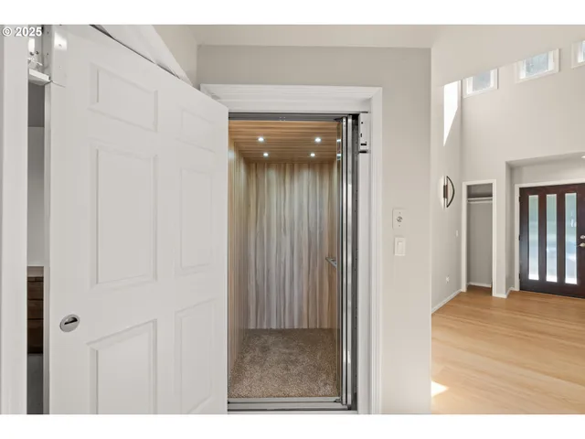 a view of a hallway with wooden floor and entryway