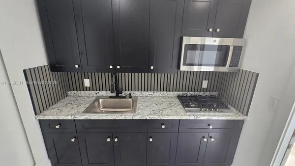 a bathroom with a granite countertop sink and mirror