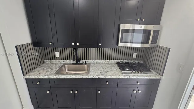 a bathroom with a granite countertop sink and mirror