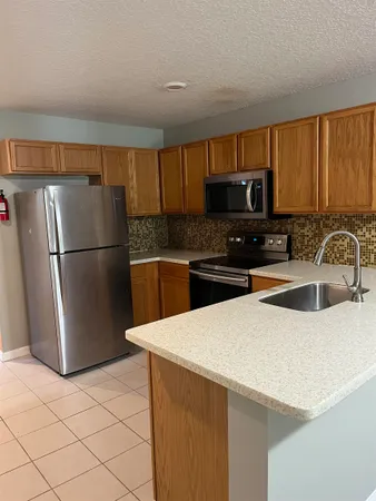 a kitchen with stainless steel appliances a refrigerator sink and microwave
