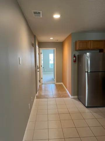 a view of a hallway with a refrigerator