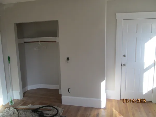 a view of walk in closet with window and wooden floor