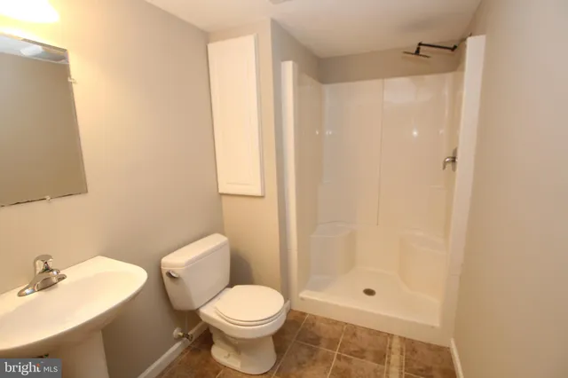 a white toilet sitting next to a bathroom sink