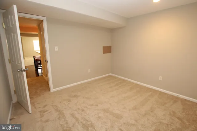an empty room with a bench and a view of bedroom