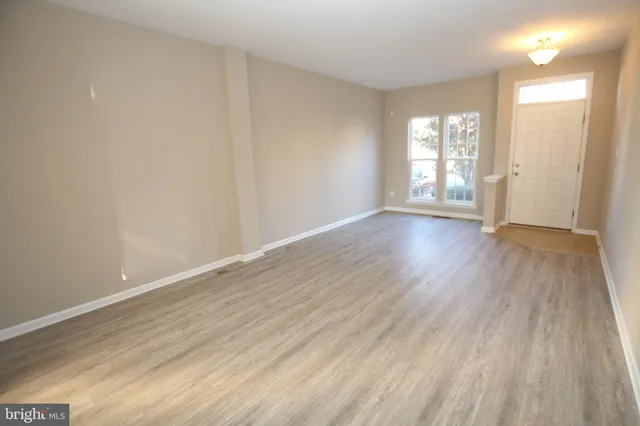 wooden floor in an empty room with a window