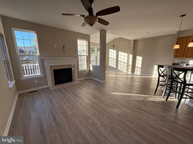 a view of empty room with wooden floor and fireplace