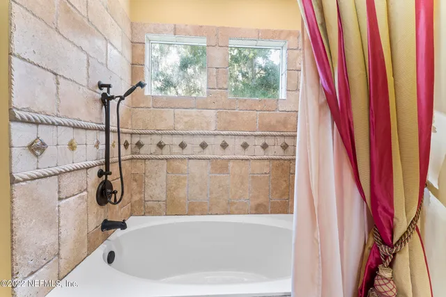 a spacious bedroom with a bed and a chandelier