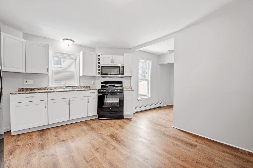 256 Belmont Street Worcester, MA 01604 - Photo 16 of 40 a kitchen with wooden floors and white appliances