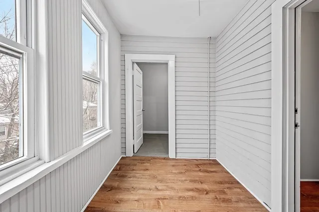 a view of a hallway with wooden floor and windows