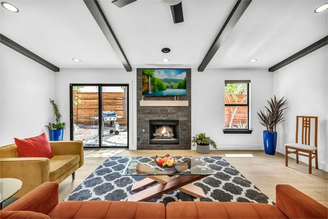 a living room with furniture fireplace and a large window