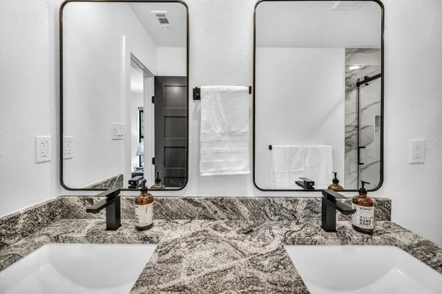 a bathroom with a granite countertop sink and a mirror