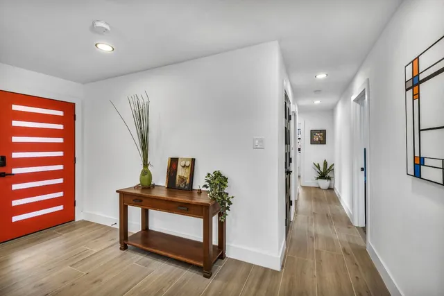 a view of hallway with furniture and wooden floor