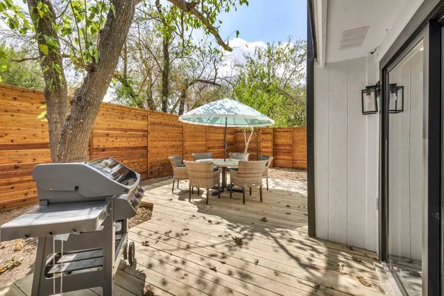 a view of a patio with table and chairs under an umbrella