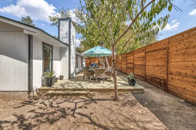 a view of a patio with a table and chairs under an umbrella