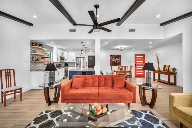 a living room with furniture a wooden floor and next to a window