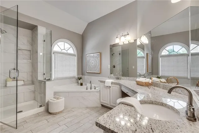 a large white bathroom with a granite countertop toilet a sink and a large mirror