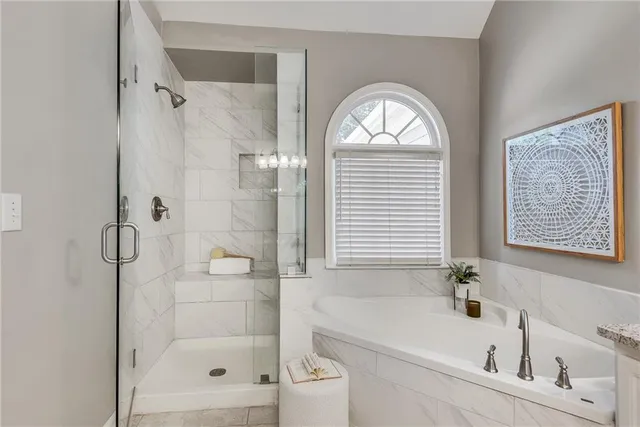 a bathroom with a bathtub a shower and a vanity