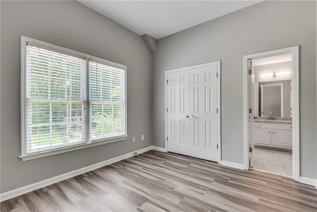 a view of an empty room with window and bathroom