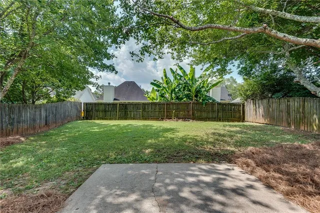 a view of a backyard with wooden fence