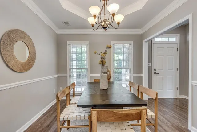 a view of a dining room with furniture a chandelier and wooden floor