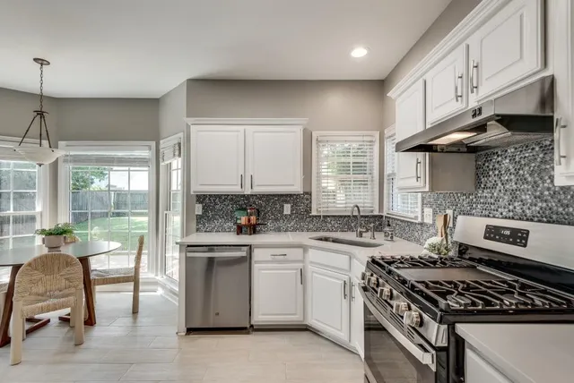 a kitchen with a stove a sink and wooden cabinets